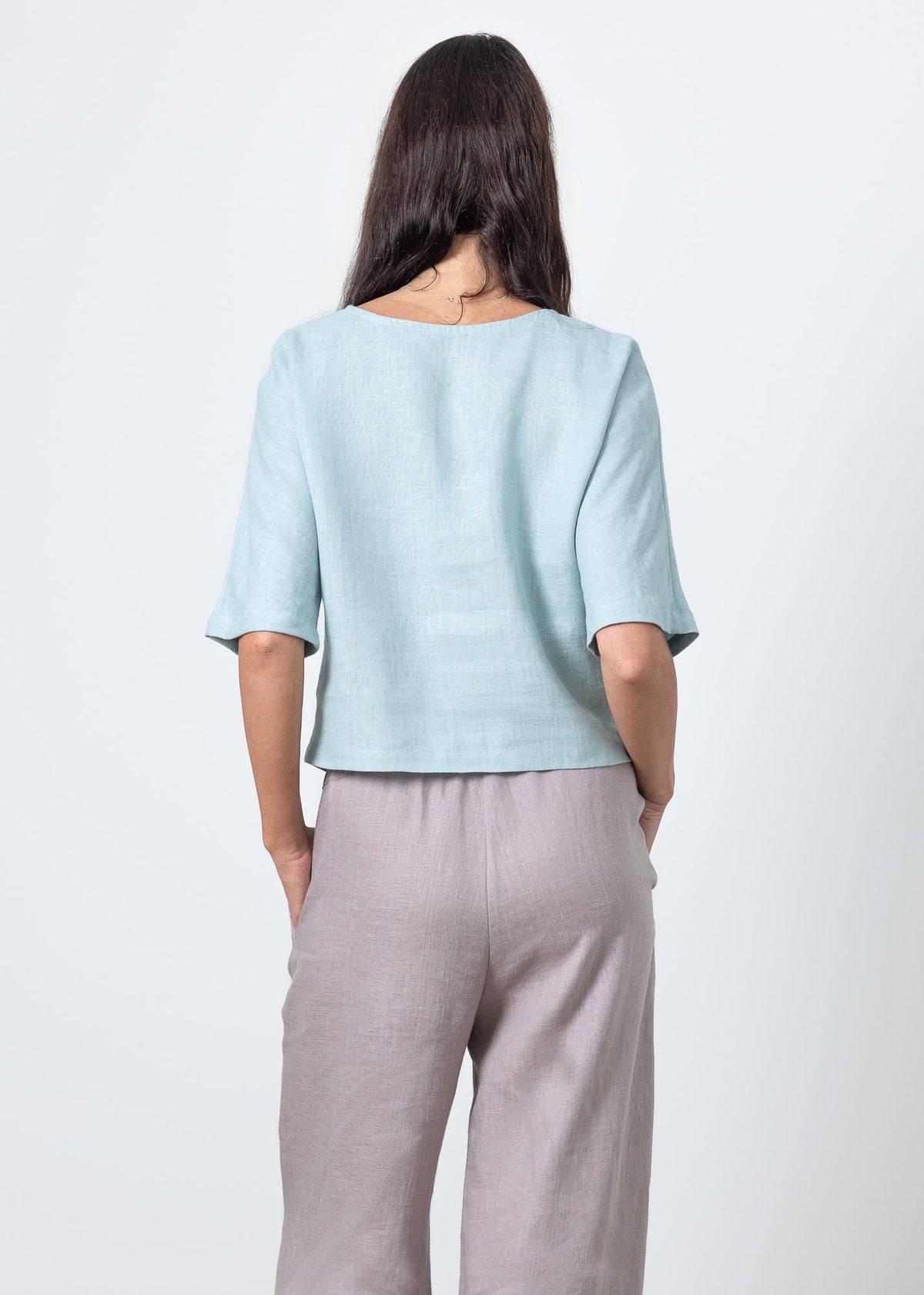 Back view of boxy linen cropped blouse in soft blue – short sleeve summer top for women