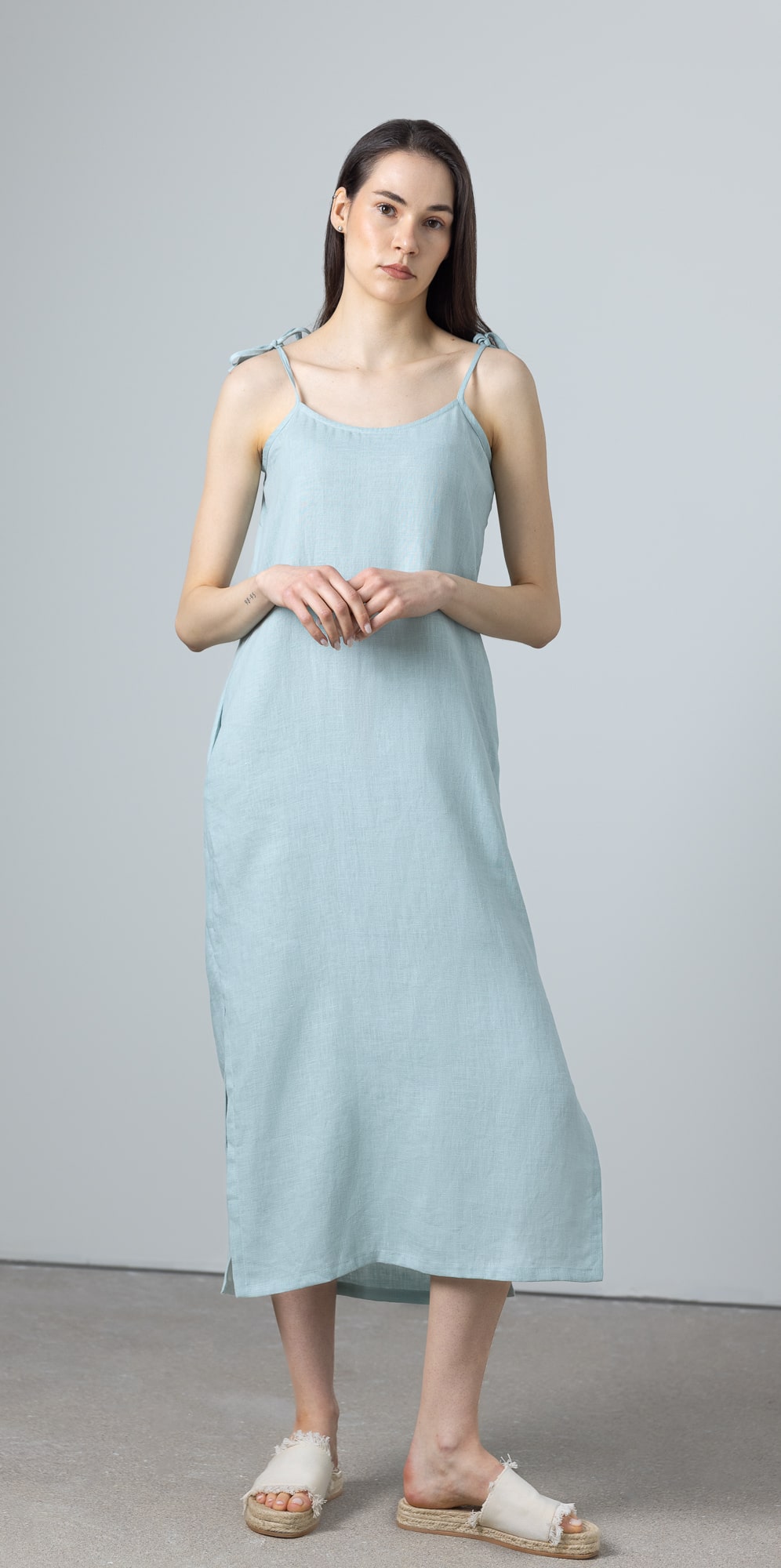 Front detail of A-line slip dress in green linen with tie straps and minimalist design, perfect as a green maxi linen dress