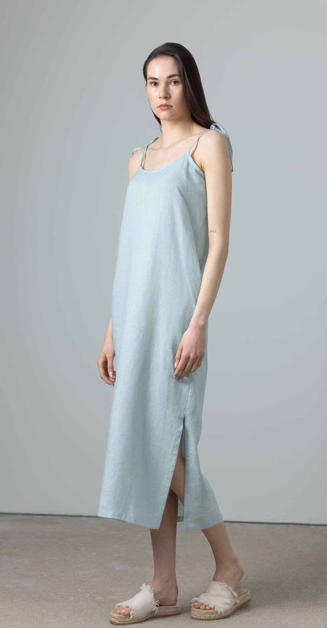 Side view of green maxi linen dress, slip dress linen style with A-line cut and adjustable tie straps for effortless summer elegance