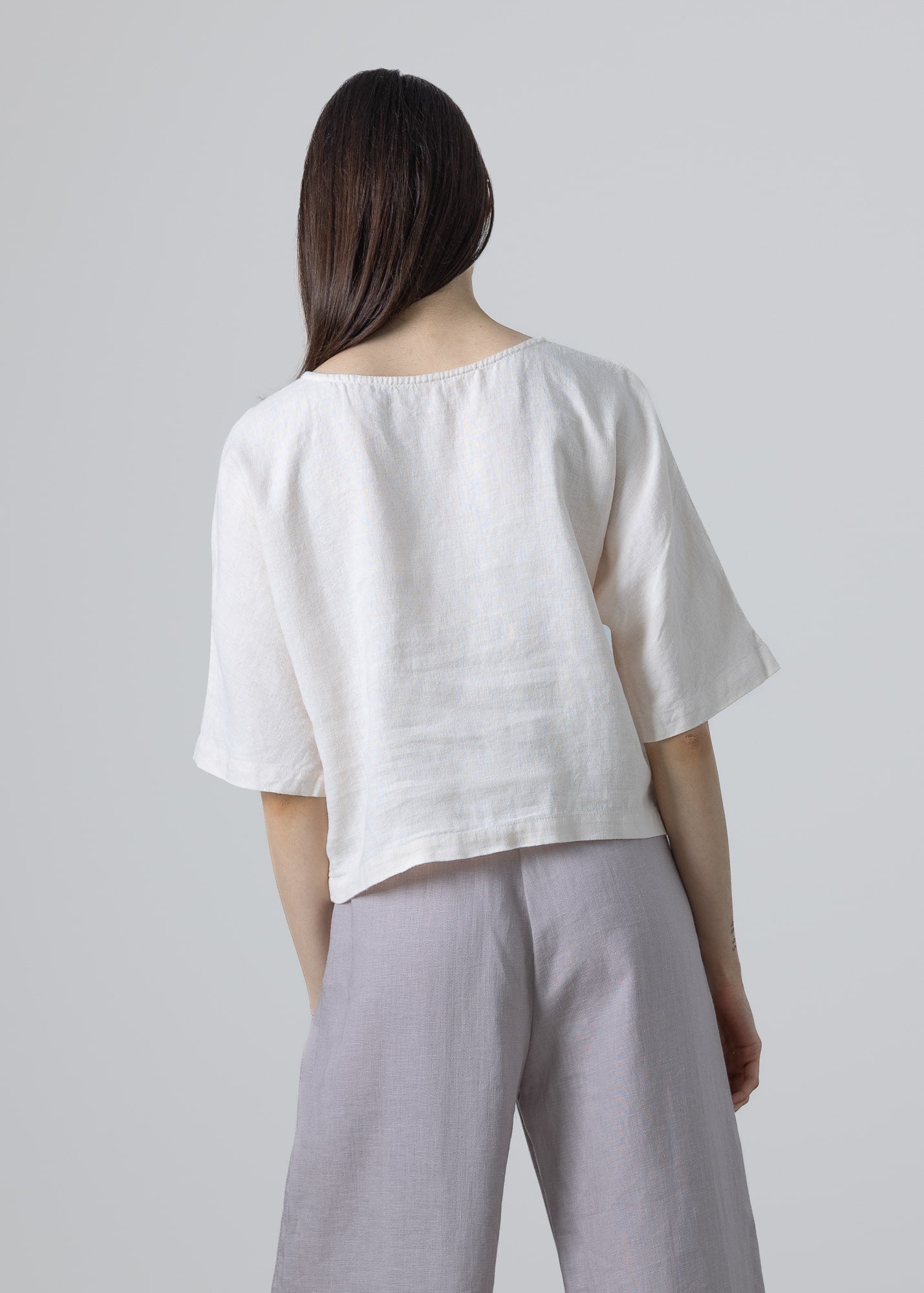 Women’s linen top outfit in white, breathable natural linen clothing styled with wide-leg trousers