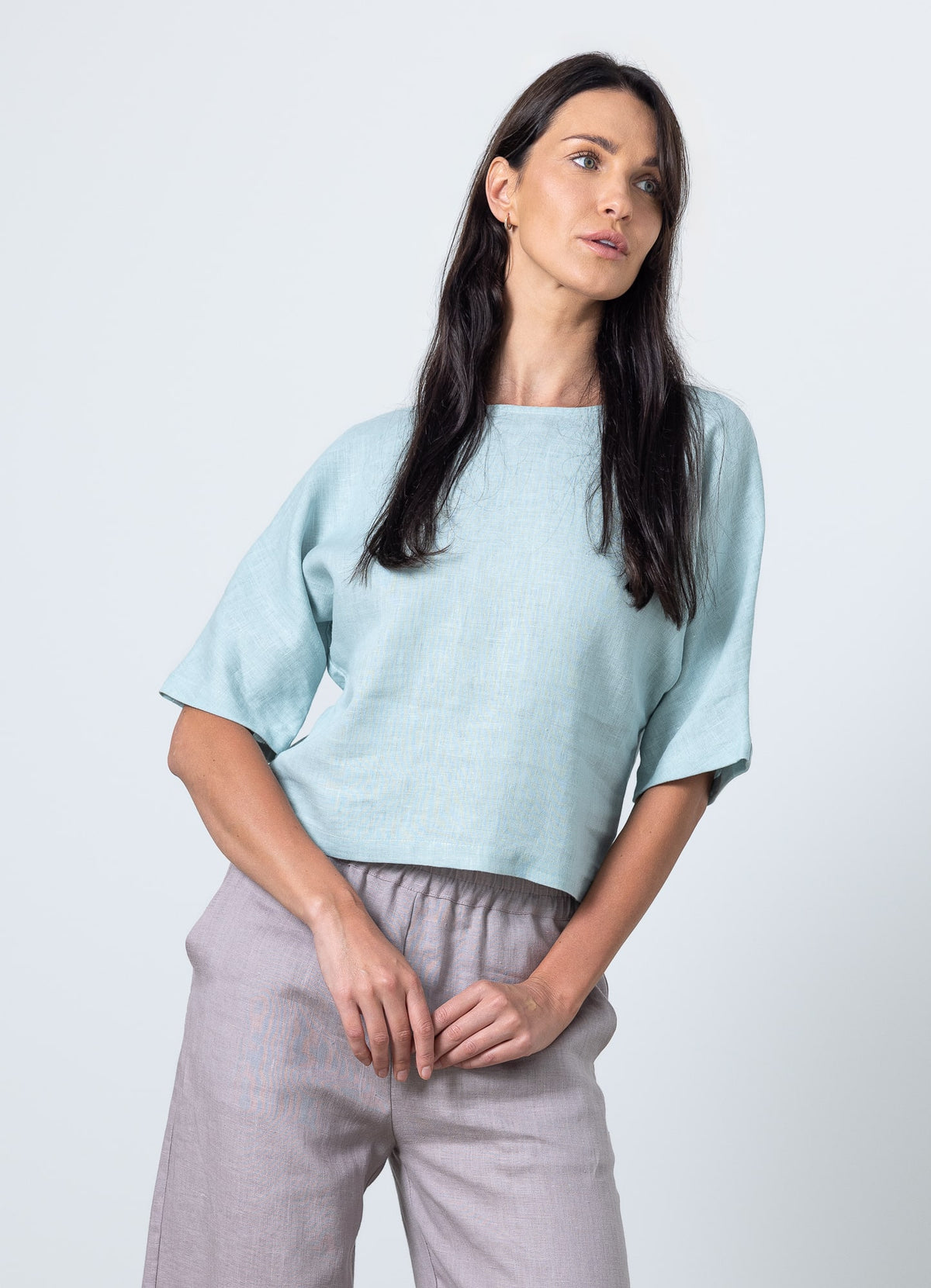 Woman wearing light blue linen crop top with boxy fit and short sleeves – front angle