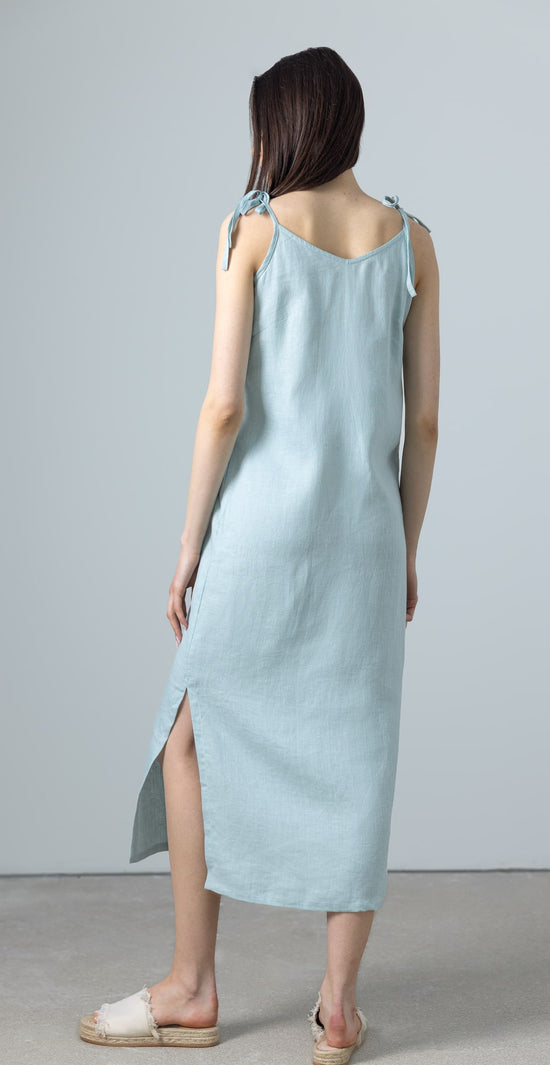 Back view of green linen A-line slip dress with side slit and relaxed fit, a graceful maxi linen dress in green