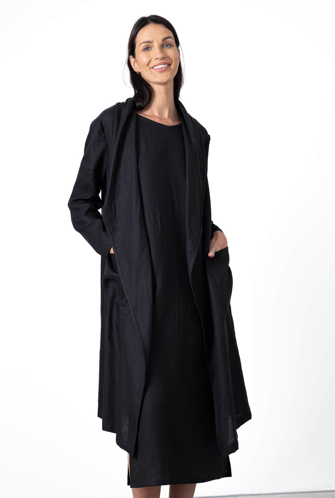 woman wearing black linen long coat with minimalist black dress outfit
