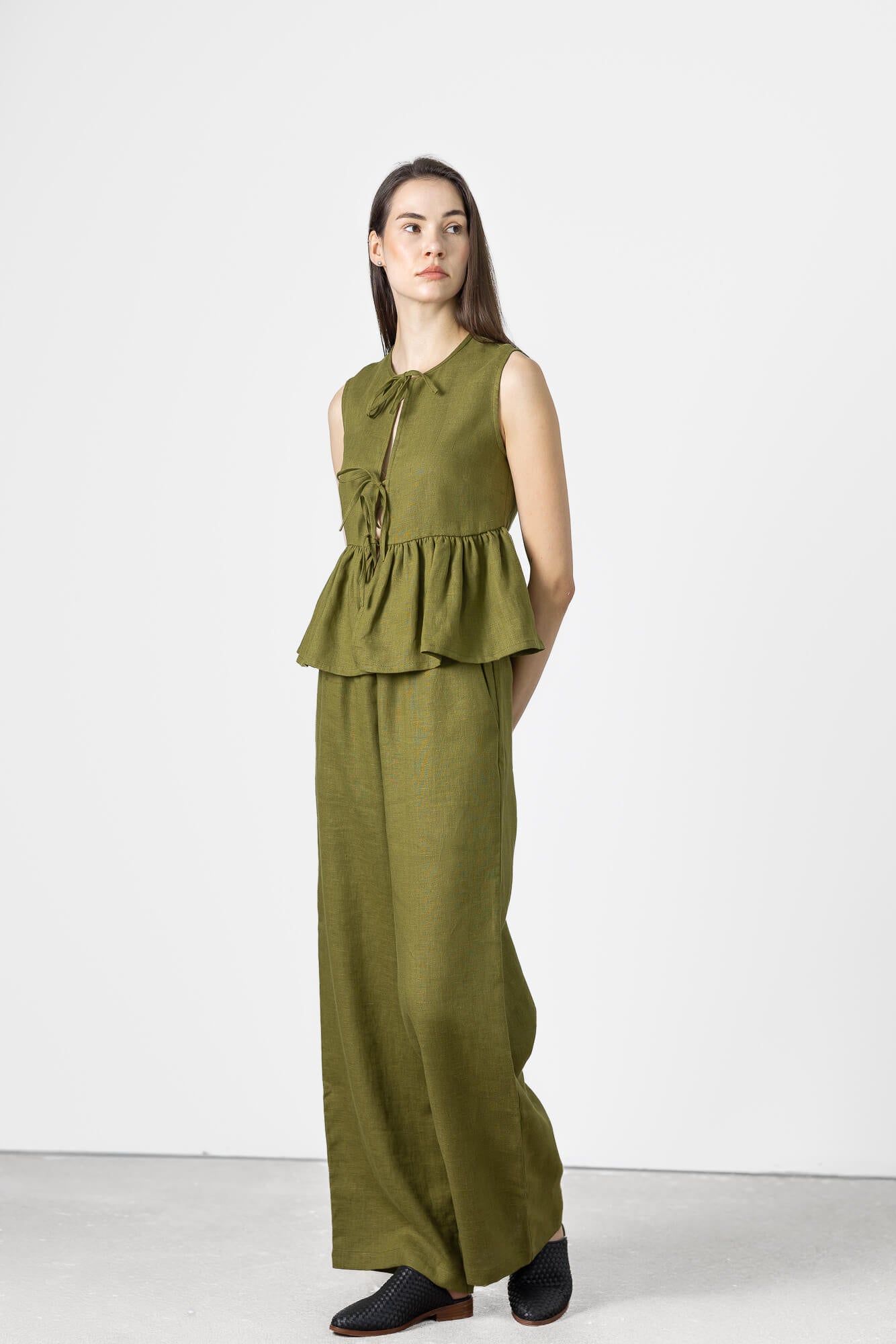Minimalist sleeveless linen vest featuring adjustable front ties and a gathered silhouette