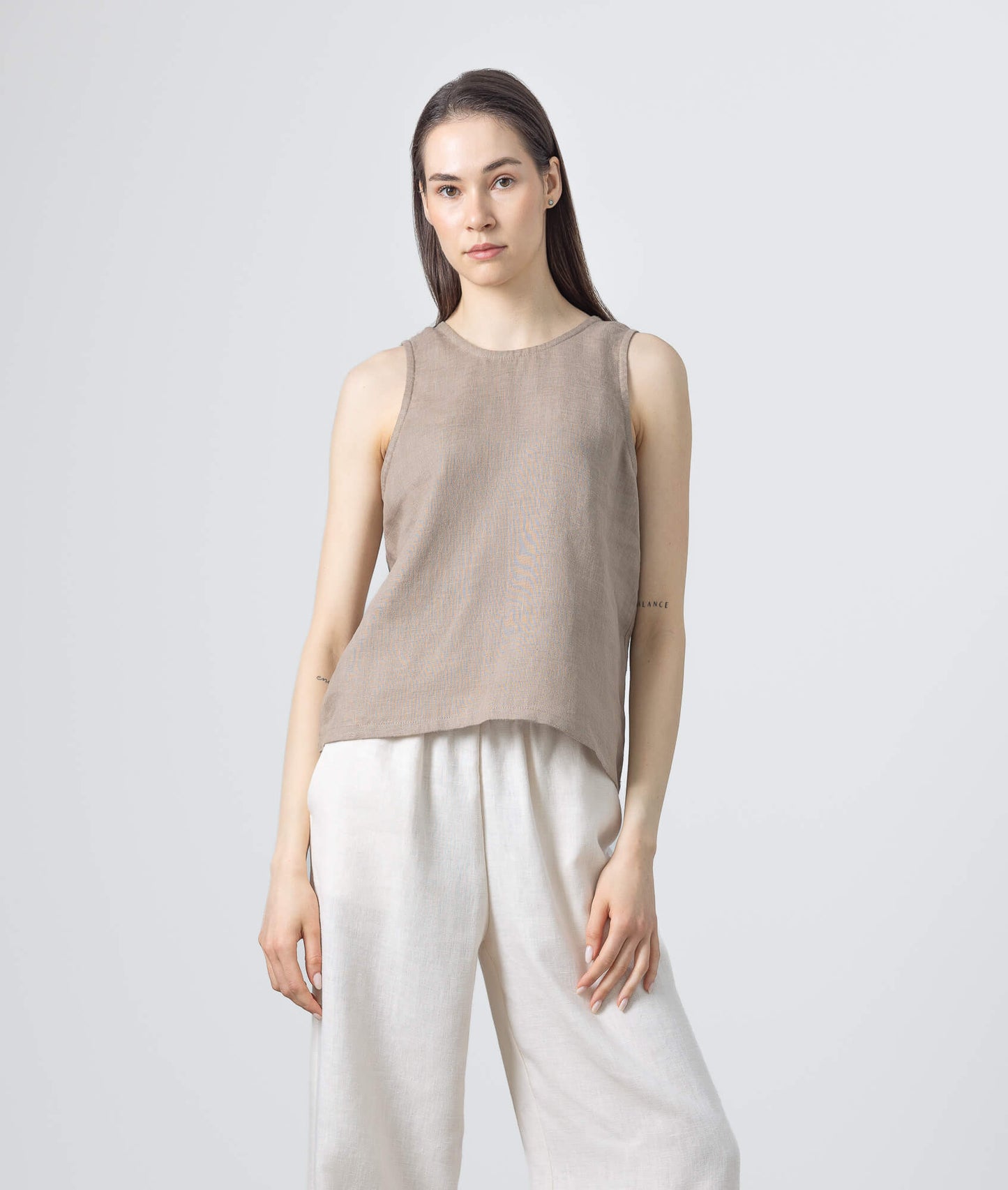 Sleeveless brown linen blouse with relaxed silhouette.