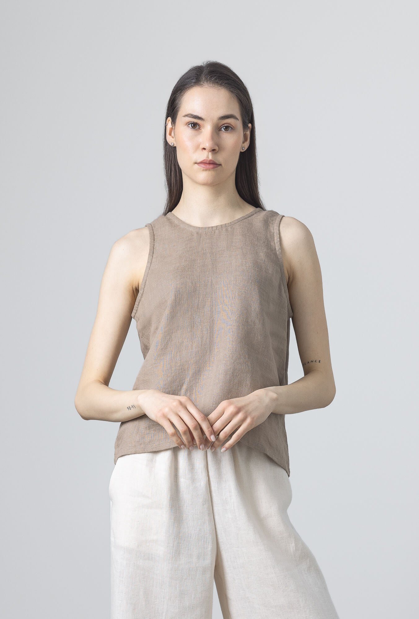 Women's casual brown linen blouse styled with linen trousers.