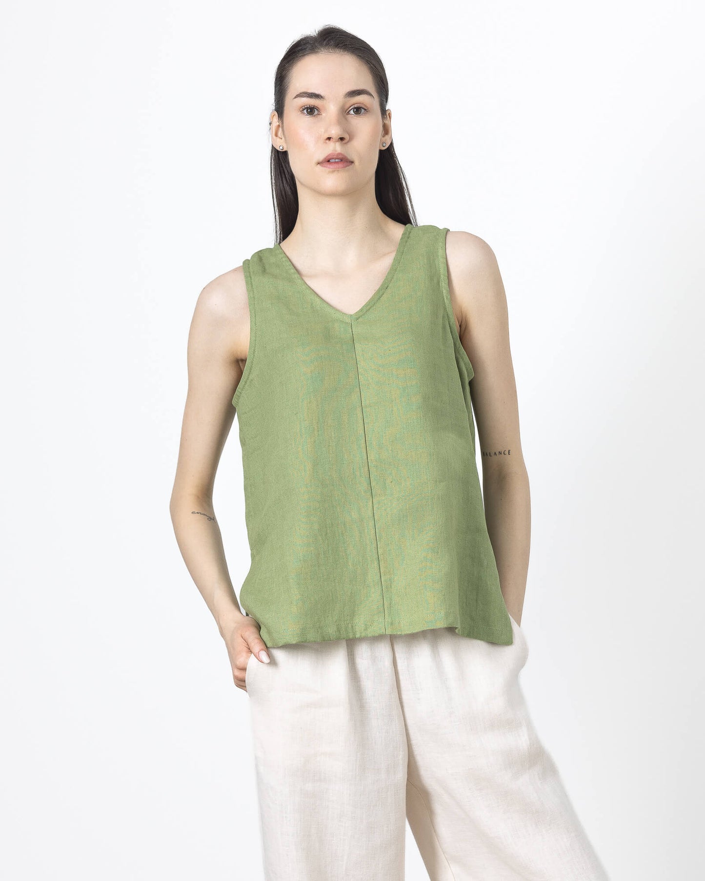 Women's green linen V-neck blouse front view with sleeveless minimalist design.