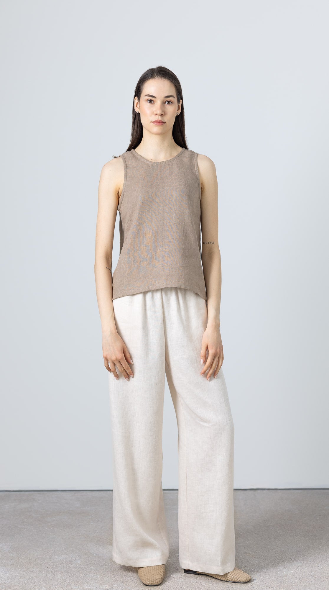 Sleeveless linen blouse for women – part of a minimalist capsule wardrobe, styled with wide-leg pants
