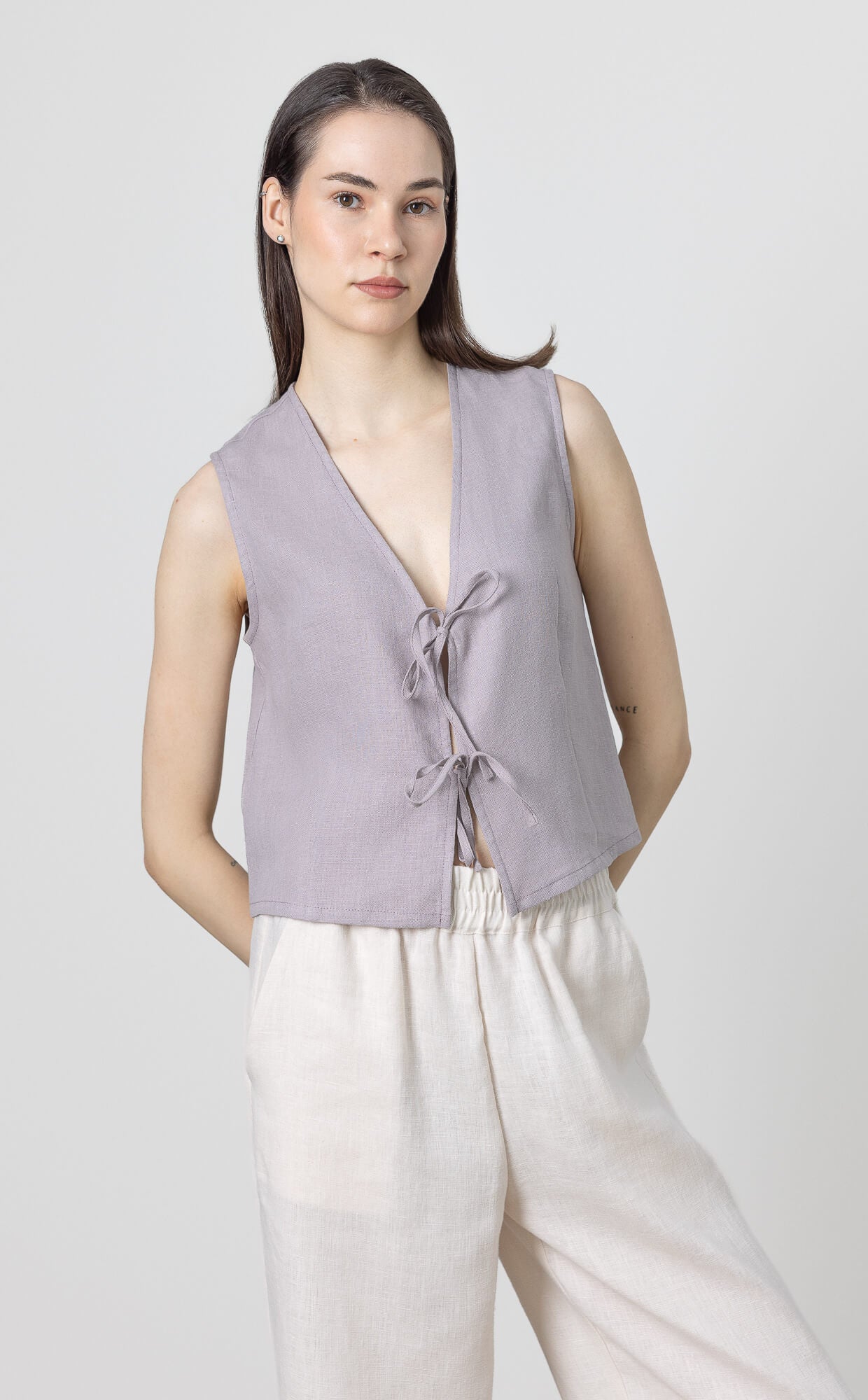 Cropped linen vest top with sleeveless design and front bow fastening