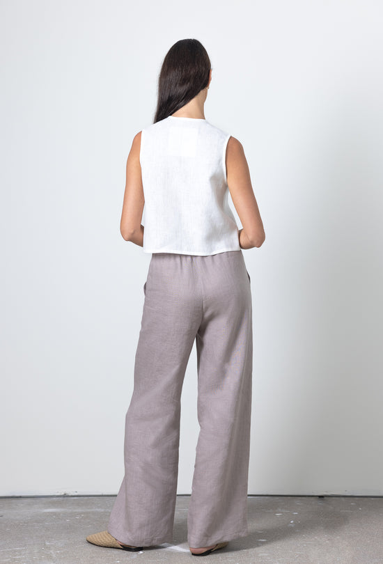 Back view of a sleeveless linen tie front top styled with wide leg trousers, breathable and elegant linen outfit