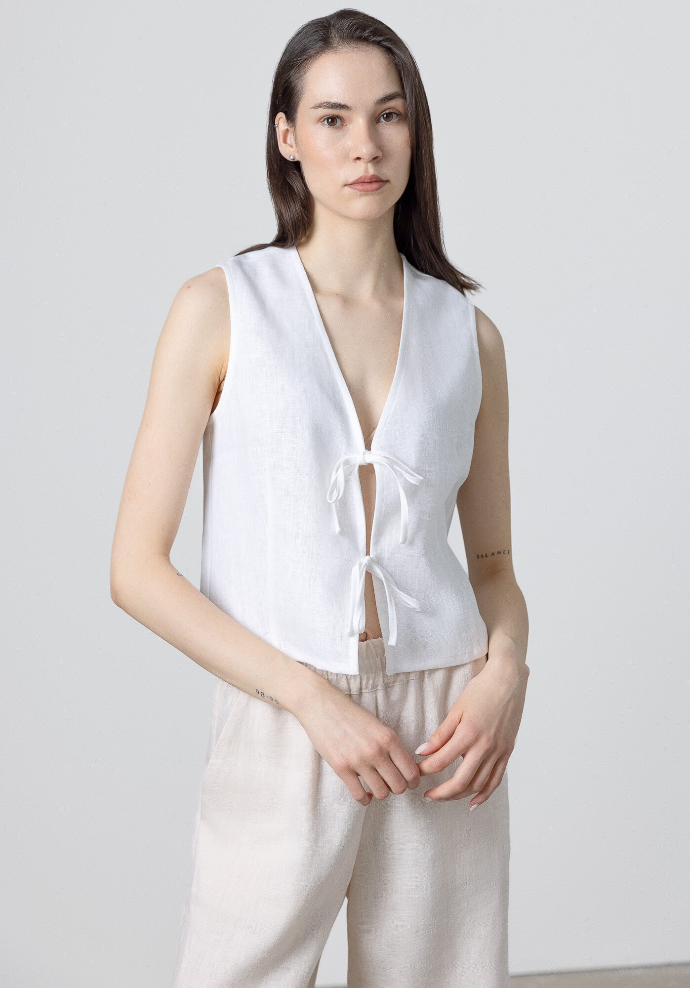 Minimalist linen outfit featuring a sleeveless vest and relaxed wide leg linen trousers