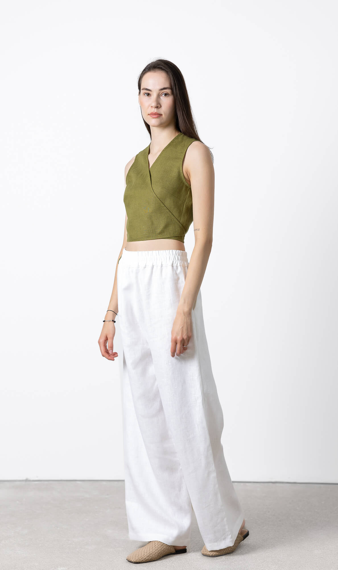 Side view of women's sleeveless linen wrap top featuring adjustable side ties, breathable cropped linen blouse crafted from OEKO-TEX® certified linen for summer outfits