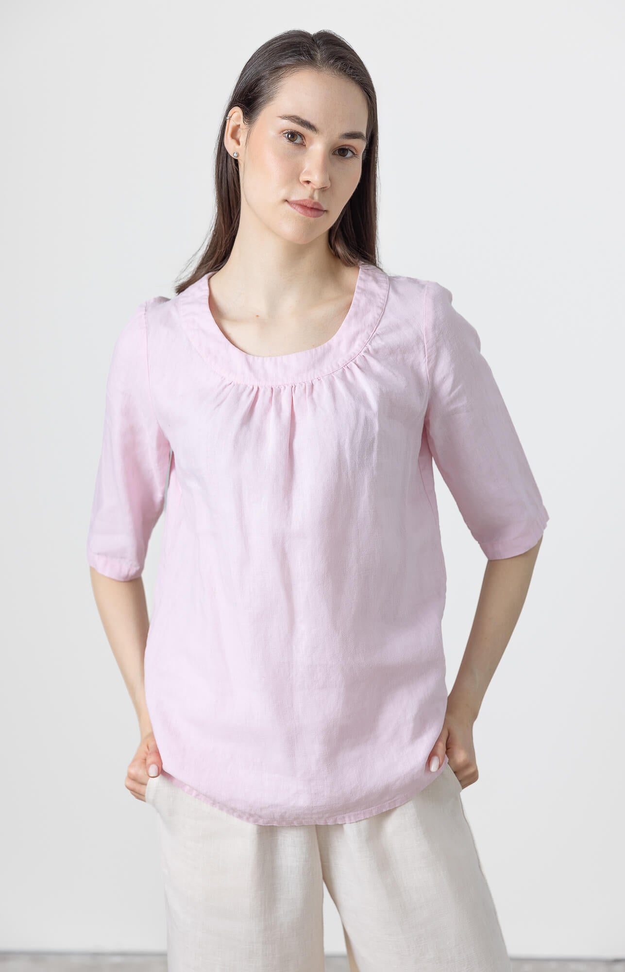 Women's minimalist pink linen blouse with gathered neckline and relaxed fit for summer.