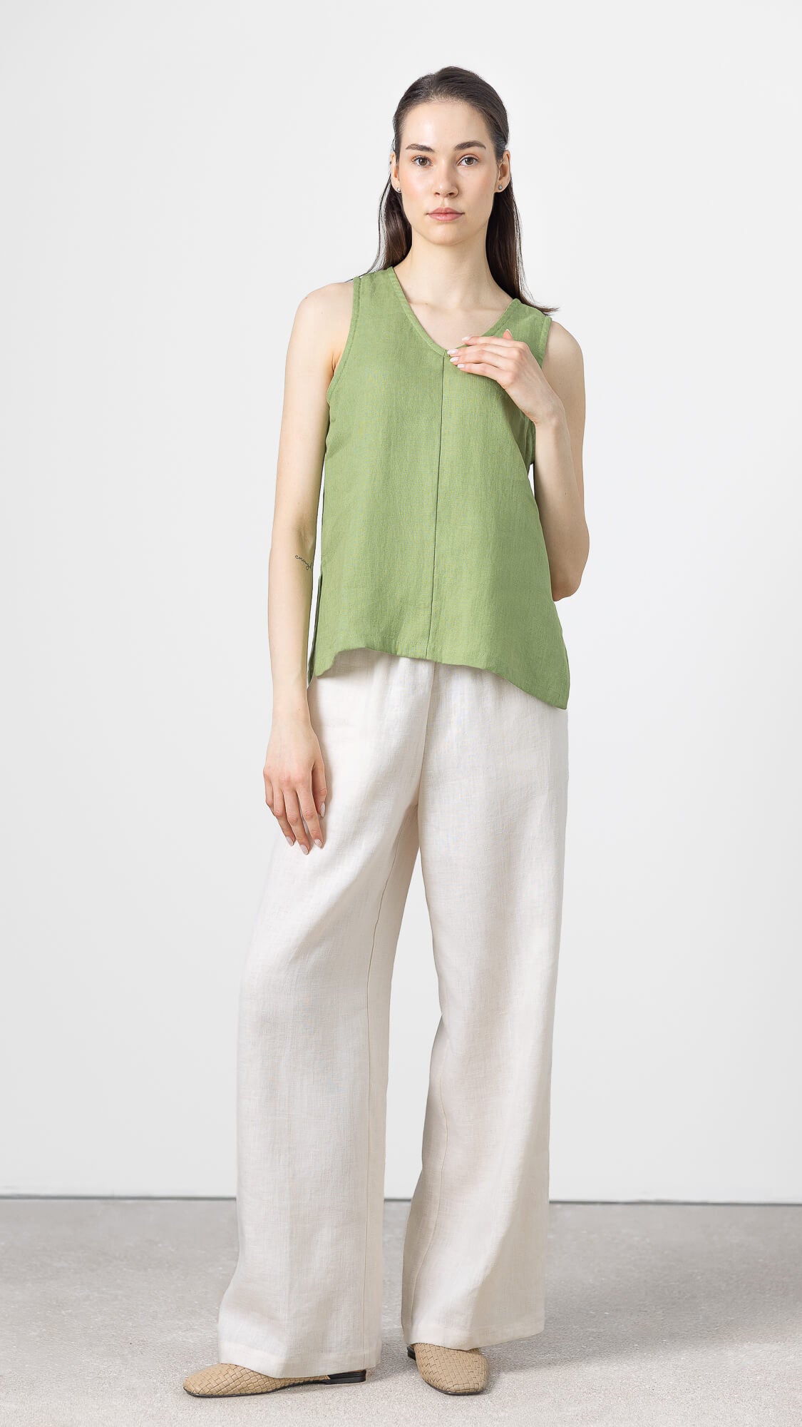 Women's olive green linen blouse with a relaxed sleeveless silhouette.