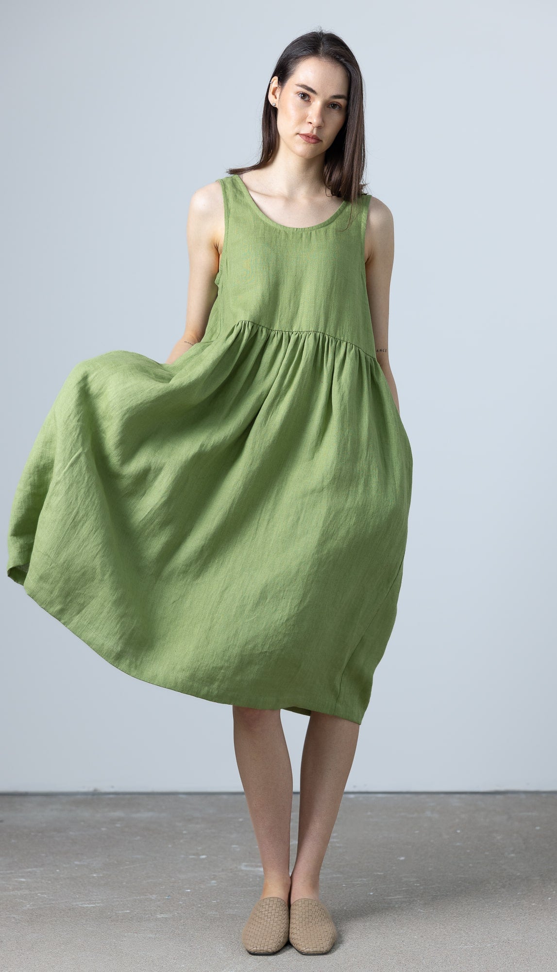 Swinging light green linen dress by MinimalisticLinen with carefree movement and feminine silhouette