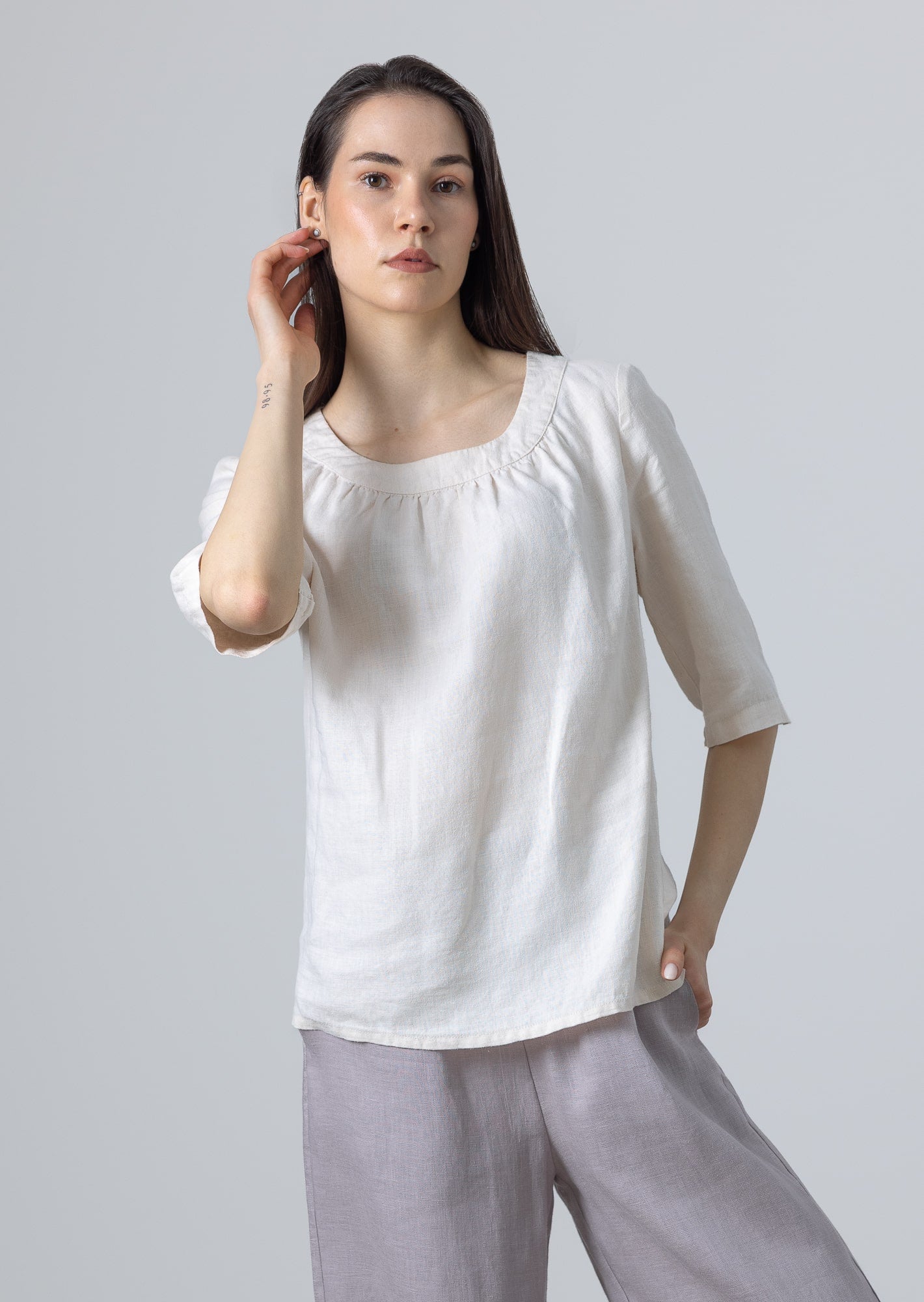 Woman styling Ladies White Linen Blouse Lily with light grey linen trousers, front pose