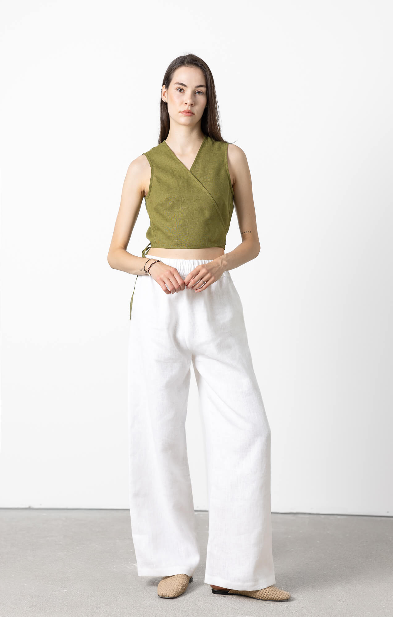 Front view of minimalist sleeveless linen crop wrap top with adjustable tie closure, lightweight breathable OEKO-TEX® certified linen top for casual and vacation wear