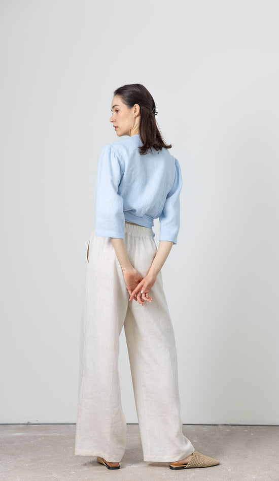 Soft blue women's linen wrap top styled with wide-leg linen pants – breathable and stylish set