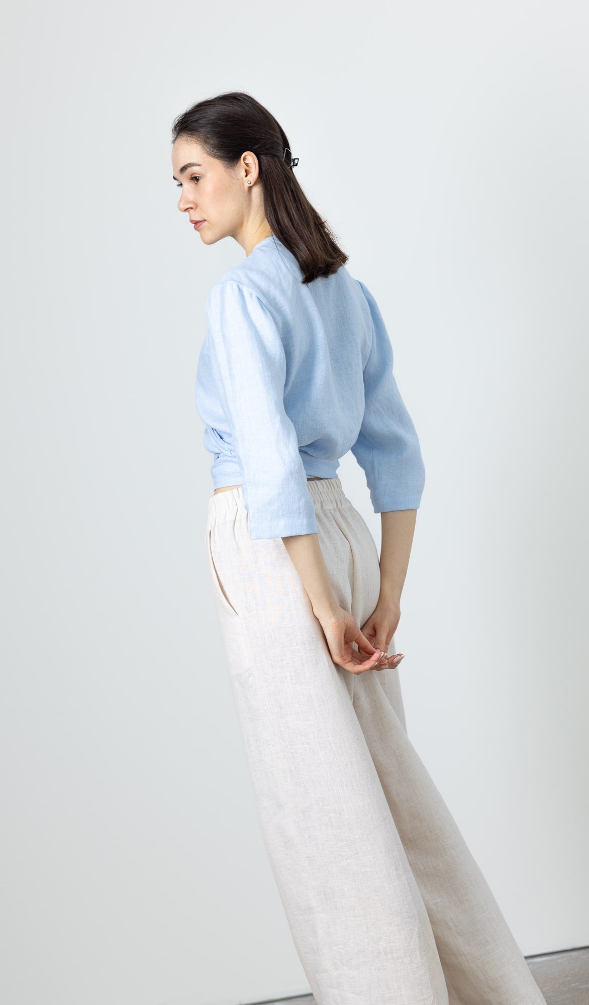 Back view of a woman wearing a blue linen wrap top – 3/4 sleeve eco-friendly blouse