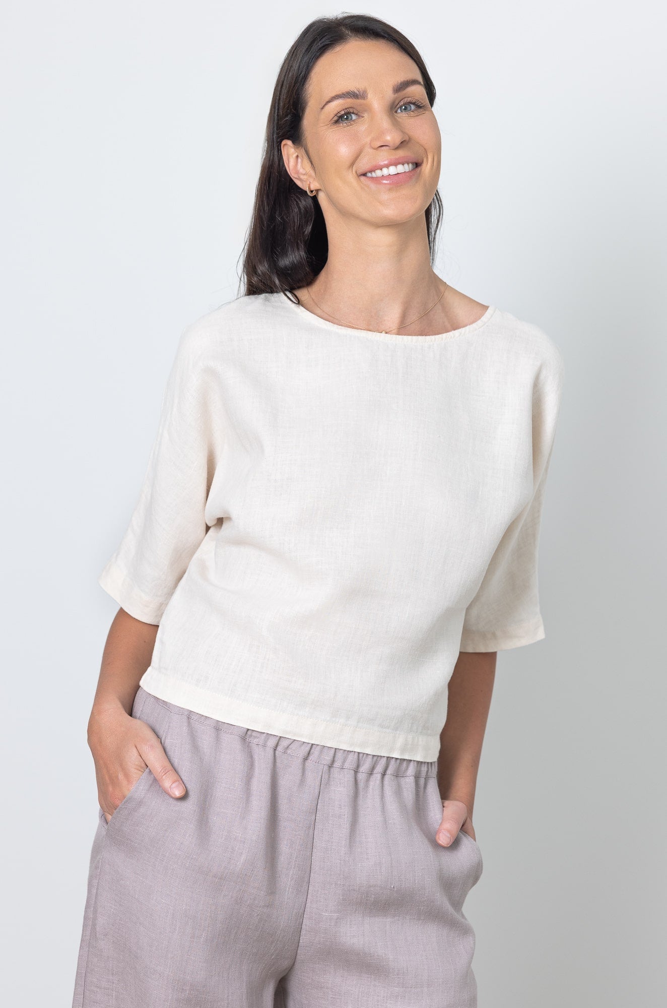 Smiling model in minimalist linen crop top and relaxed fit wide leg linen pants, perfect for warm weather