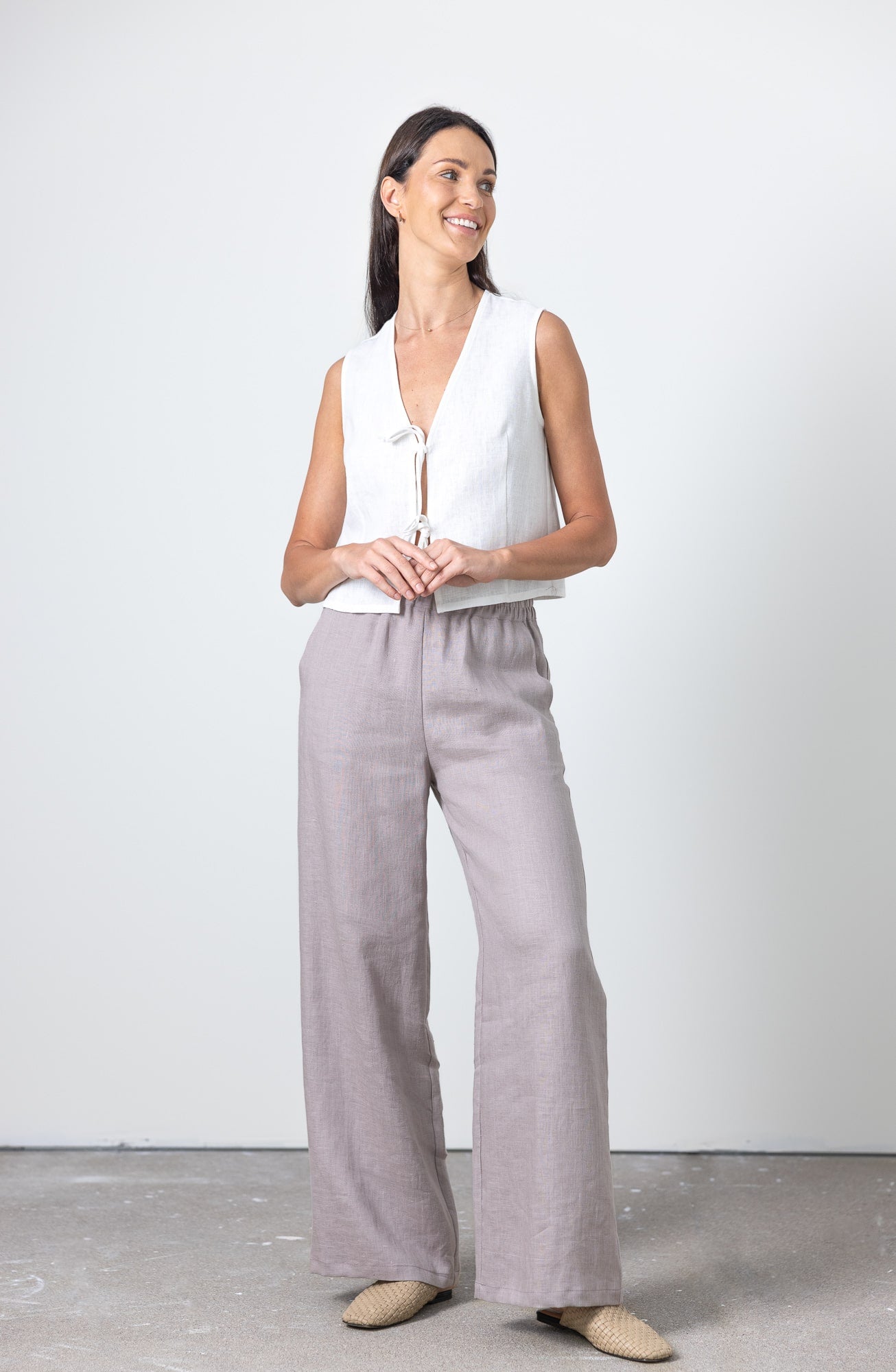 Linen wide leg trousers for women styled with a white linen waistcoat – side angle