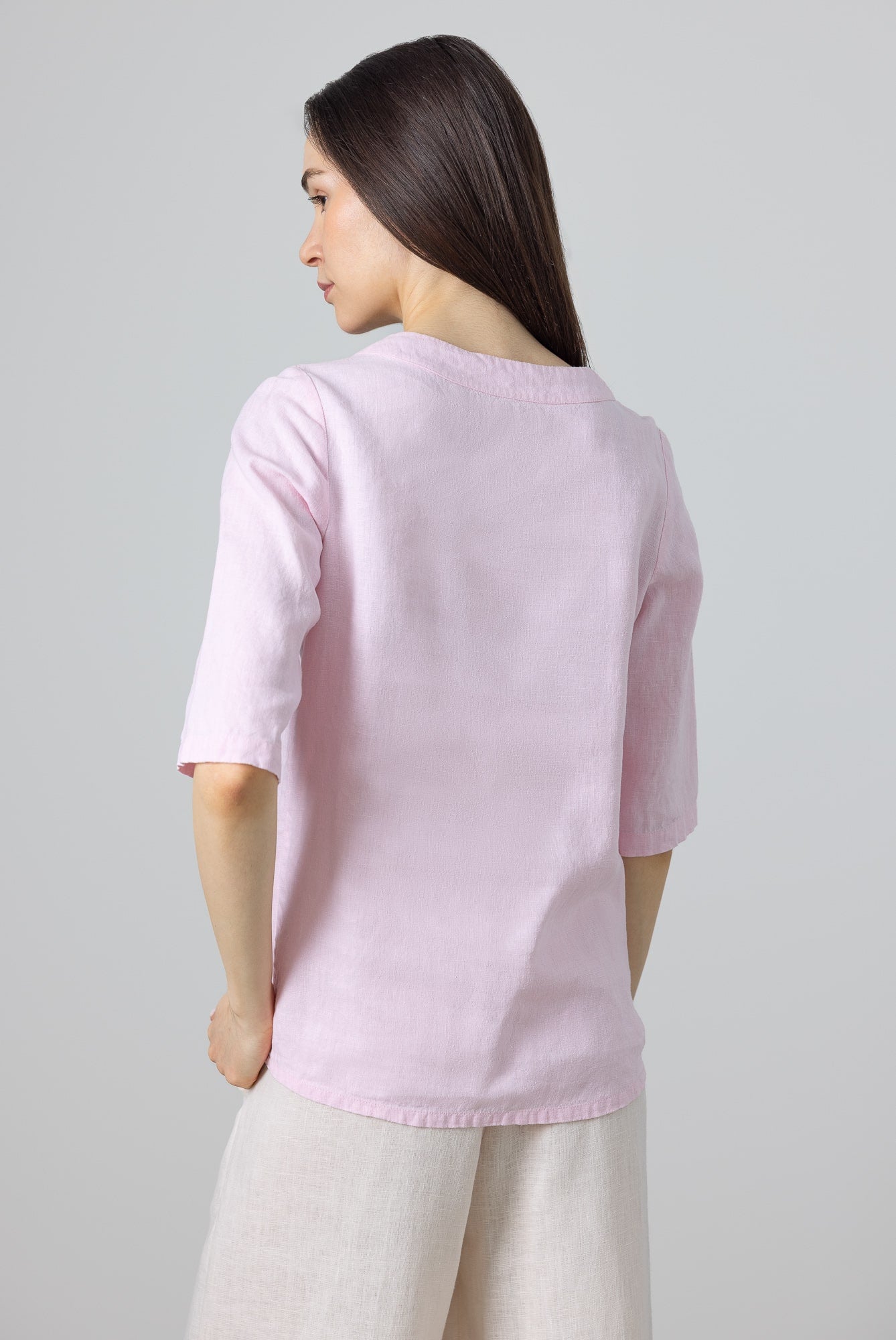 Close-up of pink ruffle neck linen blouse, designed for minimalist summer outfits